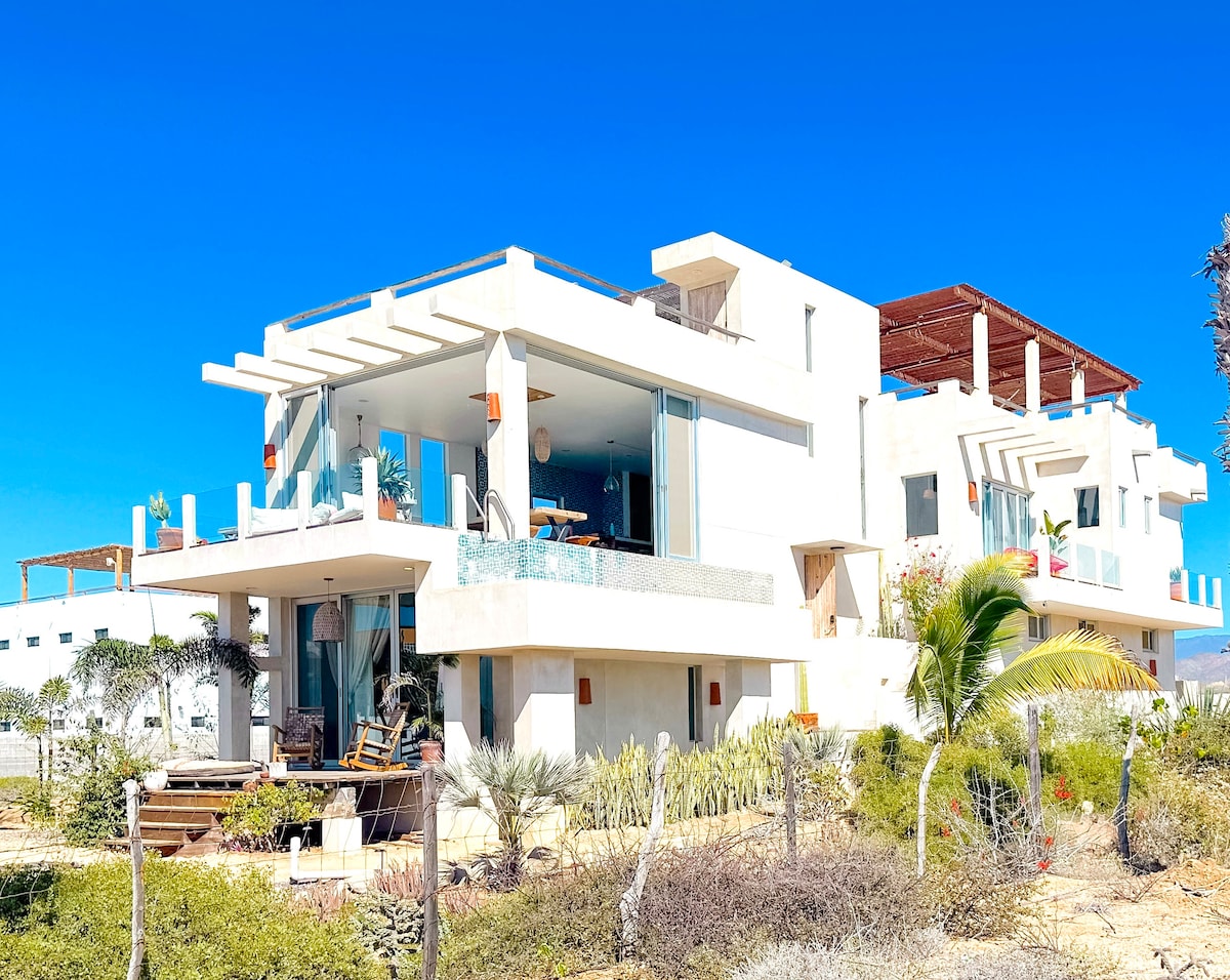 Casa Cumpleaños from the ocean side, with the open living room and rooftop palapa visible