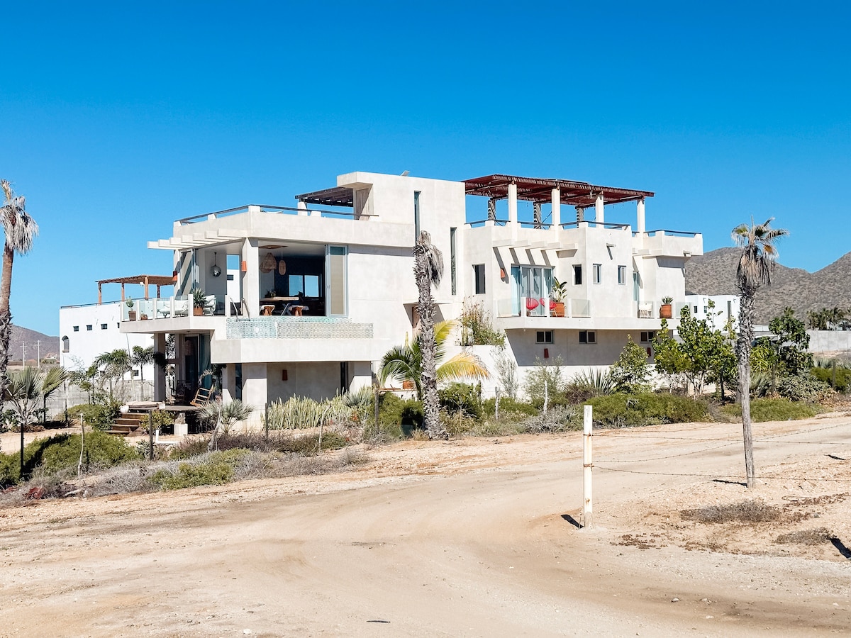 Casa Cumpleaños in its open Cerritos setting, with the foothills behind it