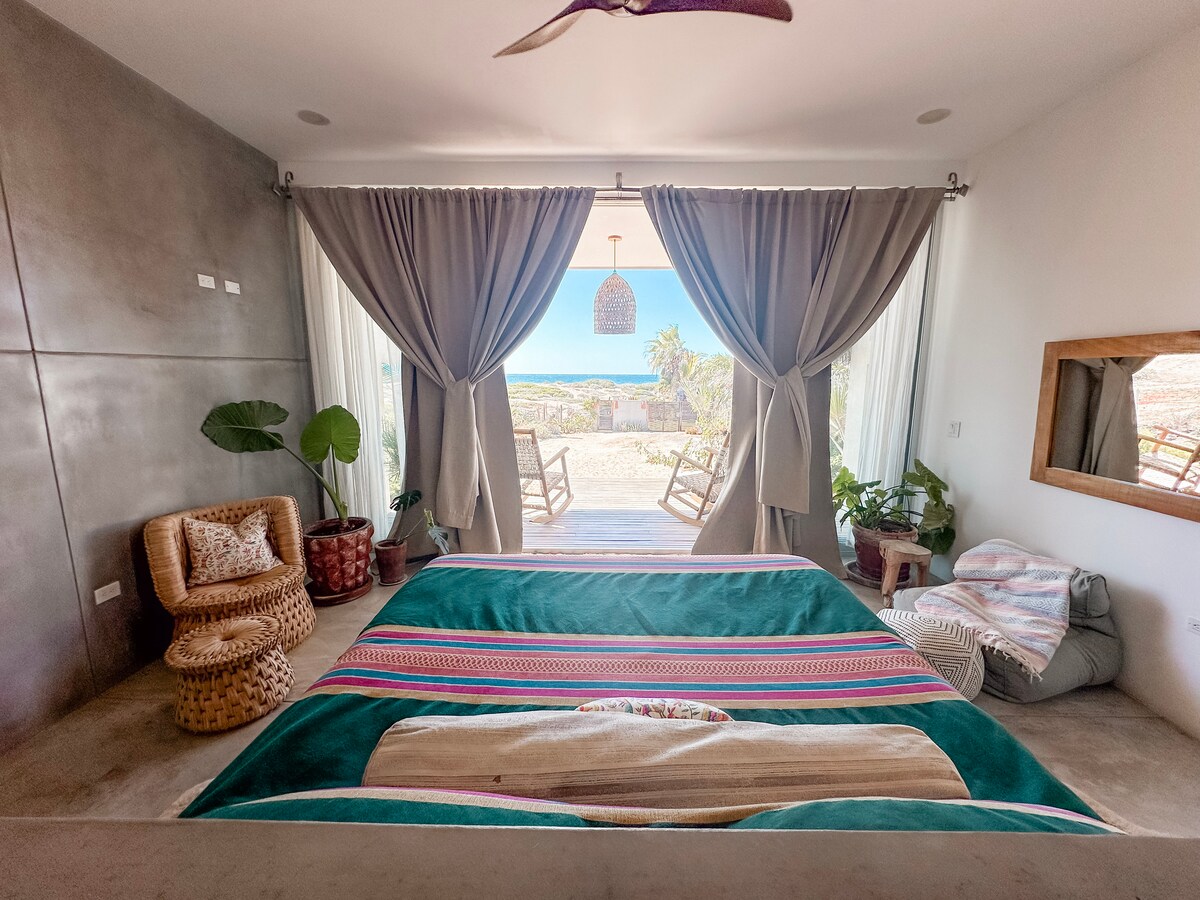 Primary suite with a king bed and doors to the ocean-facing deck