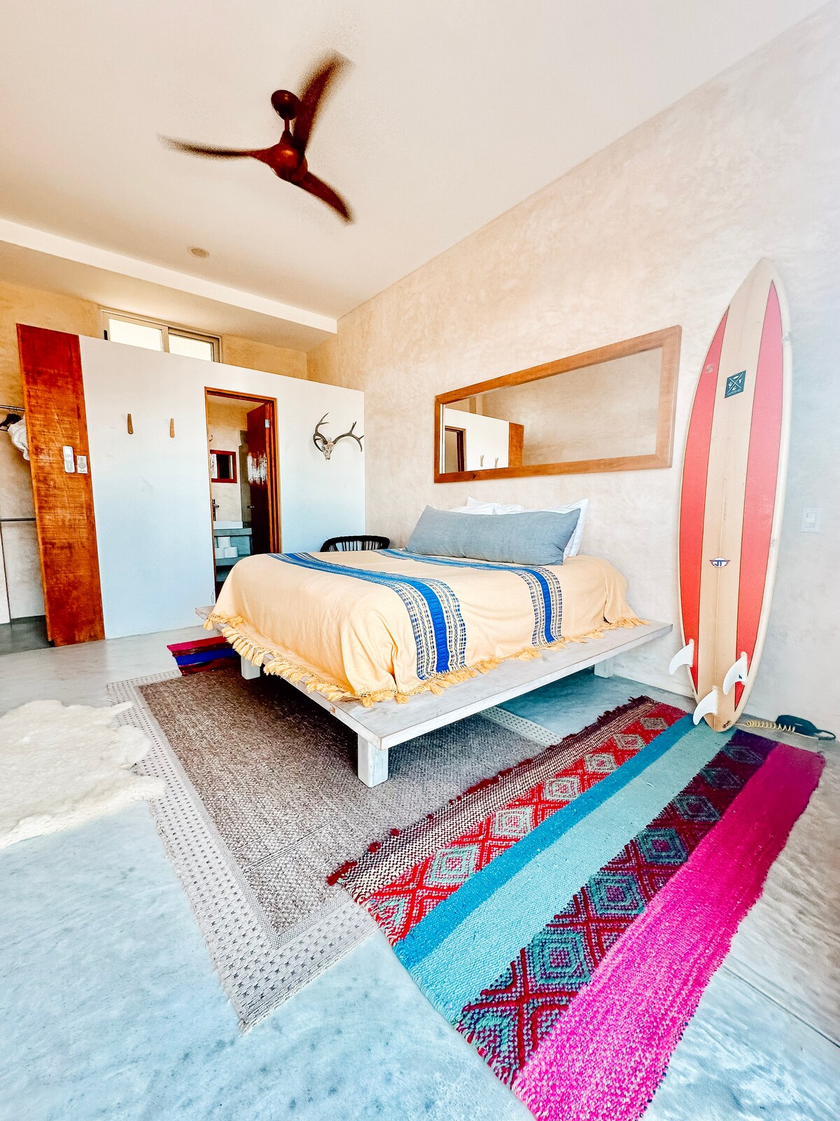 Garden-level bedroom with a queen bed and two surfboards